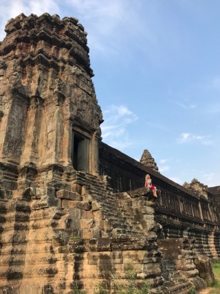 Adventure Photographer Dailyn Matthews sitting on the temple edge at Angkor Wat in Siem Reap, Cambodia