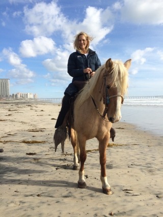Adventure Photographer Dailyn Matthews riding a horse on the beach in Rosarito Beach, Mexico
