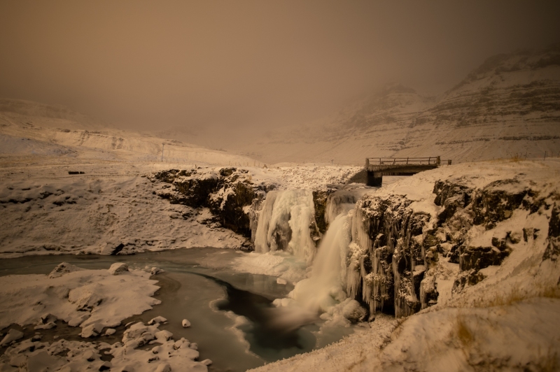 Partially frozen Kirkjufellsfoss waterfall at night in Iceland photographed by Adventure Photographer, Dailyn Matthews