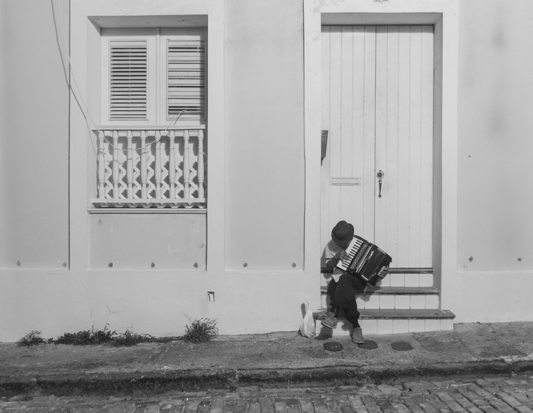 Accordion player on a stoop in Old San Juan, Puerto Rico photographed by Adventure Photographer, Dailyn Matthews